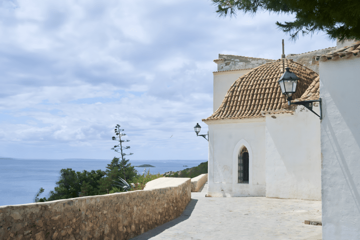 Weißes Haus auf einem Hügel in Ibiza mit dem Meer im Hintergrund