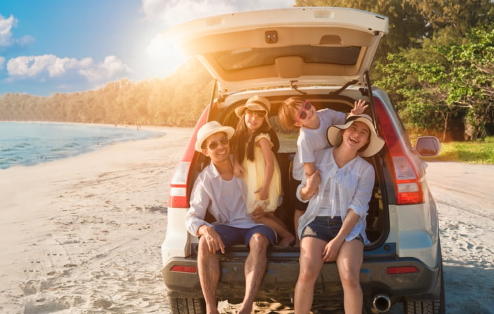 Familie im Auto am Strand