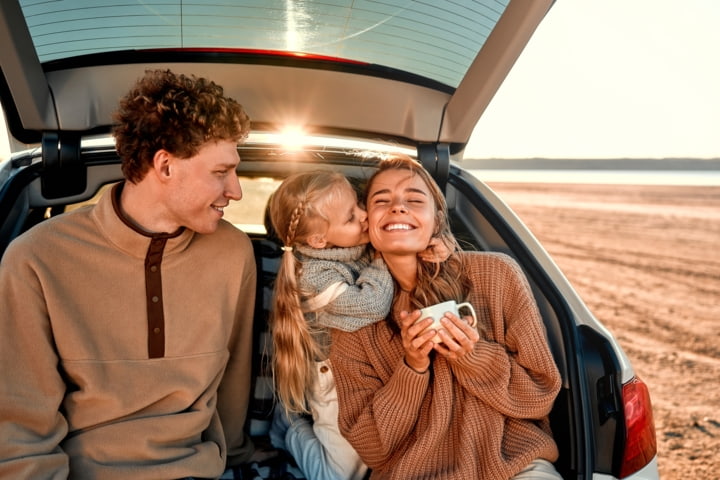 Familie im Mietwagen am Strand